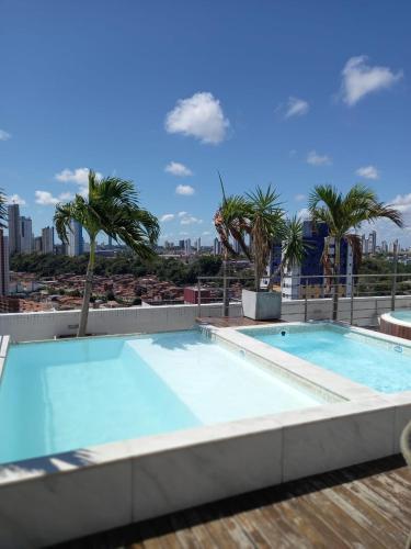 若昂佩索阿Manaíra Apart Hotel - 1606的棕榈树建筑屋顶上的游泳池