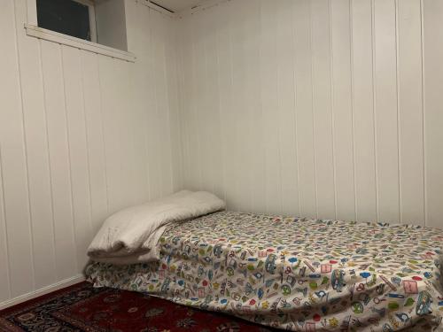 桑讷菲尤尔Råstadveien 20的小卧室配有一张带毯子的床