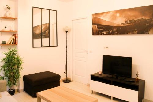 巴黎Cosy 38 m love nest near Centquatre-Paris的客厅配有白色墙壁上的平面电视。