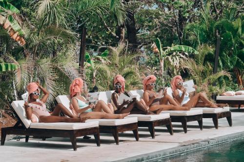 圣卡塔利娜岛Villa Coco的一群坐在游泳池畔的躺椅上的女人