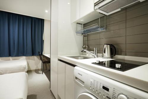 首尔Top Hotel & Residence的一间带水槽和炉灶的小厨房