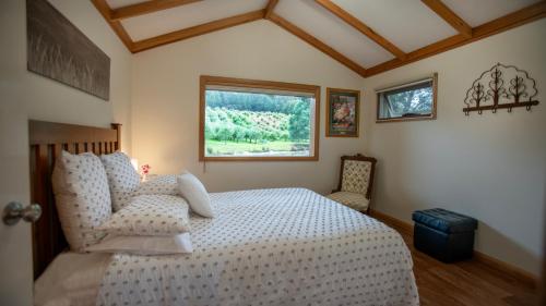 WoodbridgeWanderers Cottage的卧室配有白色的床和窗户。