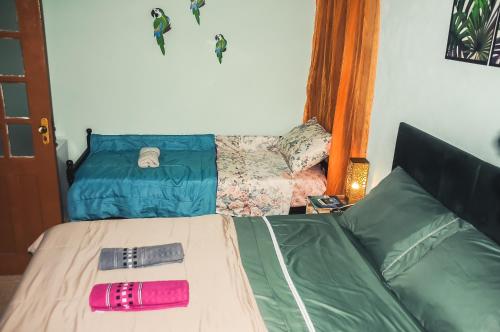 伊利亚贝拉Suítes Cocaia的一间卧室配有一张带粉色和绿袋的床