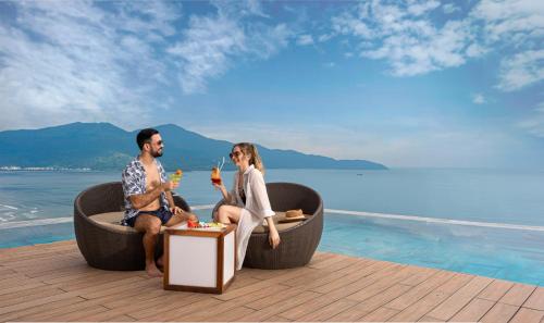 岘港乐卡尔特岘港海滩酒店的坐在水边圆形浴缸中的男女