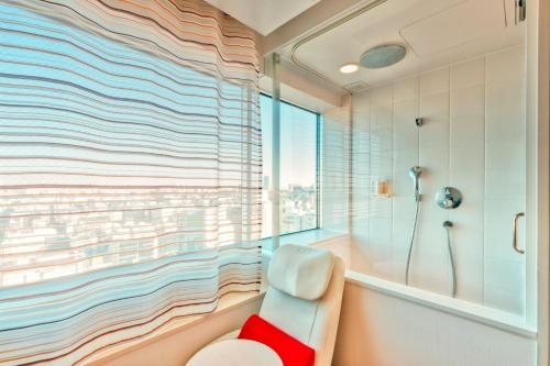 东京remm Akihabara的一间带浴缸和淋浴的浴室,并设有一个窗户
