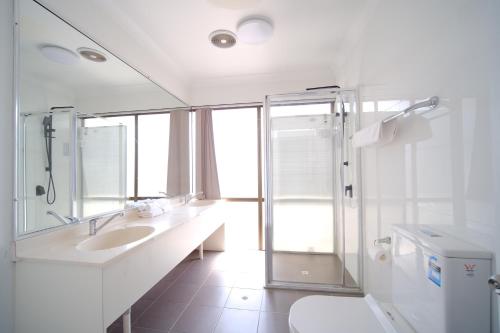 卧龙岗Lakeside Inn Wollongong的白色的浴室设有水槽和淋浴。