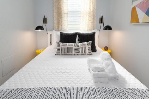 杰克逊维尔海滩Be A Nomad Beachside Apartments的卧室配有带枕头的大型白色床