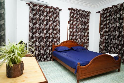 科伦坡The Anam Hotel - Wellawatte的一间卧室配有一张床、一张桌子和窗帘