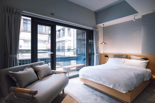基隆雨岛旅店的一间卧室配有一张床、一张沙发和一个大窗户