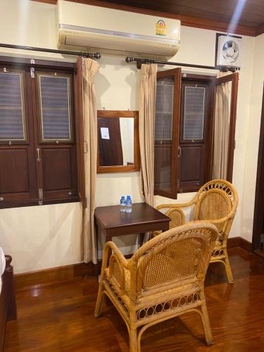 琅勃拉邦somvang khily guesthouse 宋旺吉利 酒店的配有桌子、两把椅子和一张桌子的房间
