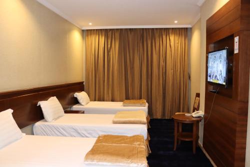 麦加فندق ضيوف المقام للغرف والشقق المفروشة的一间酒店客房,设有三张床和一台平面电视