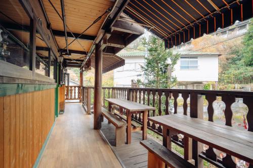 神户晨曦山林小屋酒店的阳台的甲板上设有长椅和桌子