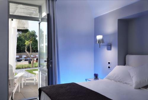 普罗奇达La Suite Boutique Hotel的一间卧室设有一张床和一个滑动玻璃门