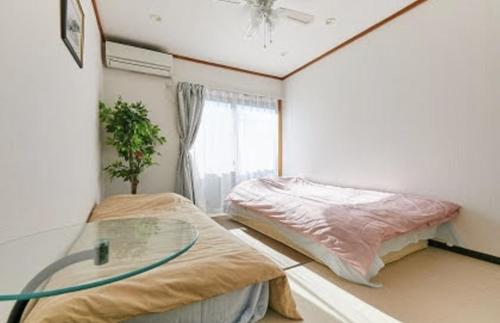 东京SHIBUYA HOUSE的带两张床和玻璃桌的房间