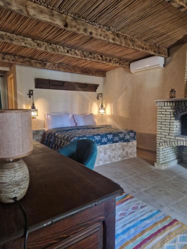 托泽尔Les Bungalows d'Armelle的酒店客房配有一张床和一个壁炉。