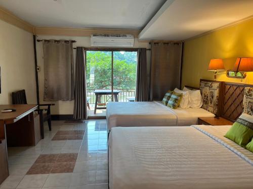 Ban Nong Nam Khan帕雅迈度假酒店的酒店客房配有两张床和一张书桌