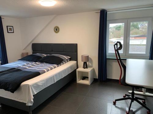 罗拉赫Günstiges Privatzimmer的一间卧室配有一张床、一张书桌和一个窗户。