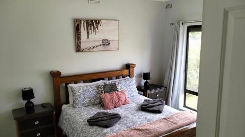 波特兰Ocean views的卧室配有带枕头的床铺,墙上挂着一幅画