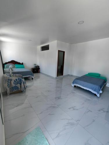 巴克里索莫雷诺港Cuarto en galápagos的一间客厅,配有两张床,铺有瓷砖地板。