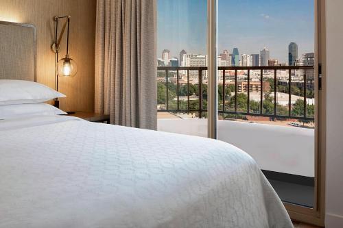 达拉斯达拉斯市场中心喜来登套房酒店的酒店客房设有一张床和一个大窗户