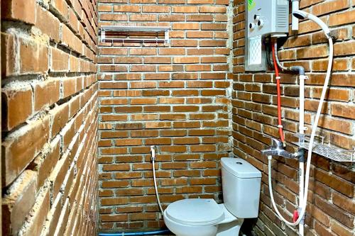 SoprayanTwoSpaces Living at Pondok Pakde, Jogja的砖墙,浴室设有厕所