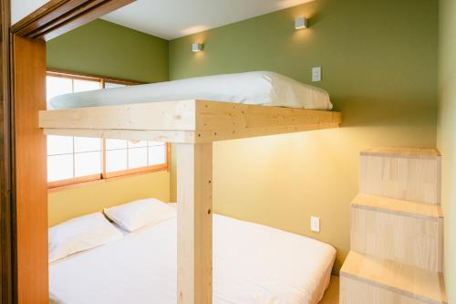 镰仓市Beach side House SHELL kamakurahase的带两张双层床的绿色墙壁客房