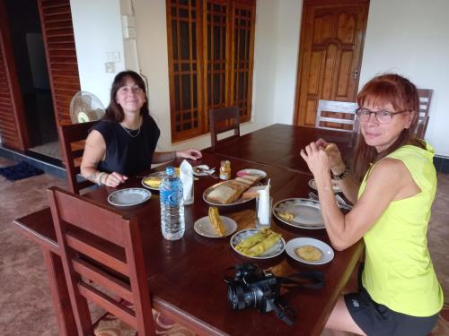 维勒珀图LLT Tourist Inn and Safari Jeep的两个坐在餐桌上吃食物的女人