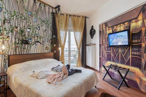 的里雅斯特Lodge&Art Hostel的一间卧室配有一张床,墙上配有电视
