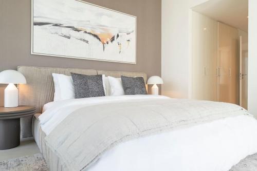迪拜Stunning Views, Luxury Residence By Chi Living的卧室配有一张白色大床和一幅画