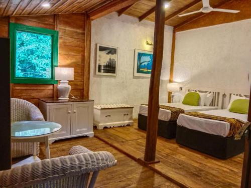 锡吉里亚Sigiriya Elegant Resort的一间卧室配有两张床和一张桌子及椅子