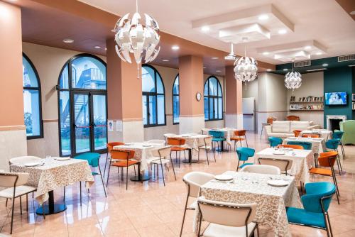 克雷马CallMe Crema - Struttura in centro storico的用餐室配有桌椅和吊灯。