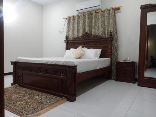 卡拉奇Nursery Inn的一间卧室配有一张带白色床单和枕头的木制床。