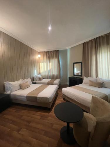 卡萨布兰卡Cadé Hotel的酒店客房,设有两张床和一张沙发