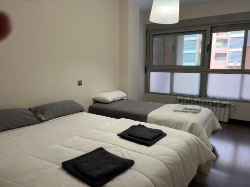 马德里Impresionante apartamento de 4 dormitorios 3 baños y 2 plazas de garaje的一间卧室设有两张床和大窗户