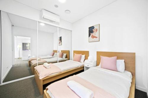 悉尼Waterfront Modern 2B2B APT@Marina square的一间卧室配有两张床和镜子