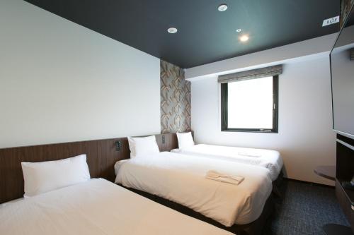 东京Henn na Hotel Tokyo Akasaka的小型客房 - 带2张床和窗户