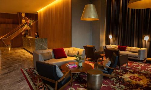 墨尔本Next Hotel Melbourne, Curio Collection by Hilton的客厅配有沙发和桌子