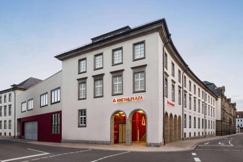 施派尔Amedia Plaza Speyer, Trademark Collection by Wyndham的街上有红色门的白色建筑