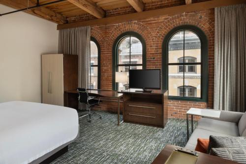 波士顿波士顿市中心万豪海港酒店的一间卧室配有一张床和一张书桌及电视