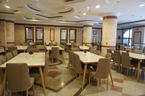 麦地那Roaa Al Andalus Hotel فندق رؤى الاندلس的一间在房间内配有桌椅的餐厅