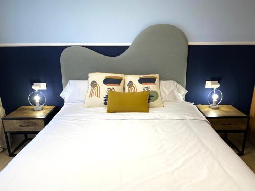 维拉Chill-out # Piscina todo el año # Playa a 650m的一间卧室配有一张带两盏灯的大型白色床。