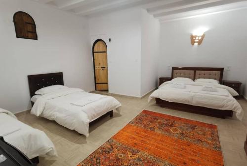 加尔达亚La Villa Tezribt的一间带两张床的卧室和地毯