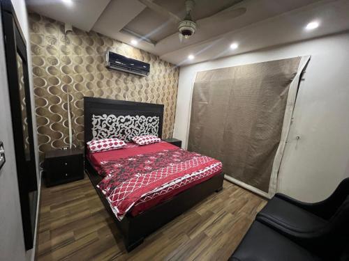 GujrānwālaPrime Plaza的一间卧室配有一张红色棉被的床