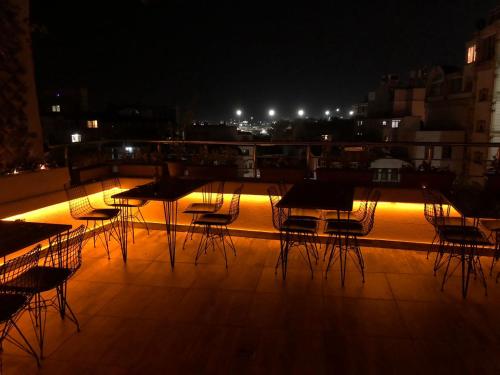 伊斯坦布尔MARDİA CİTY OTEL的一群桌子和椅子在晚上在屋顶上