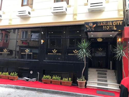 伊斯坦布尔MARDİA CİTY OTEL的楼前有盆栽植物的餐厅