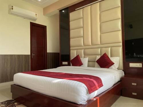 新德里Hotel Mannat International at Paschim Vihar的卧室配有带红色枕头的大型白色床