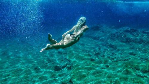 萨瓦拉Cast Away - Eco Resort的穿着泳衣的女人在水中游泳