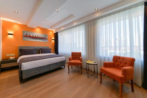 伊斯坦布尔Rise Inn Hotel的一间卧室配有一张特大号床和两把椅子