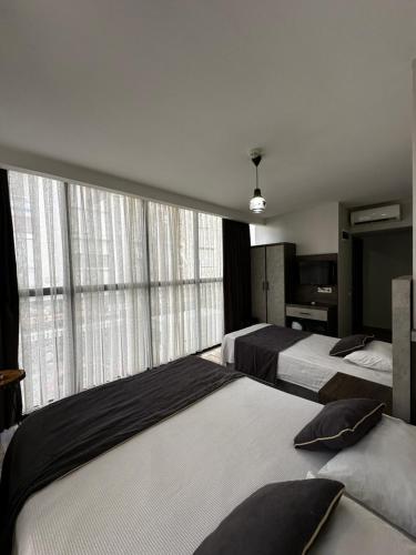 安塔利亚Comfort Başaran OTEL的一间卧室设有两张床和大窗户