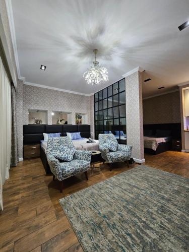 第比利斯Old Tbilisi Apartments1的客厅配有一张床和两把椅子